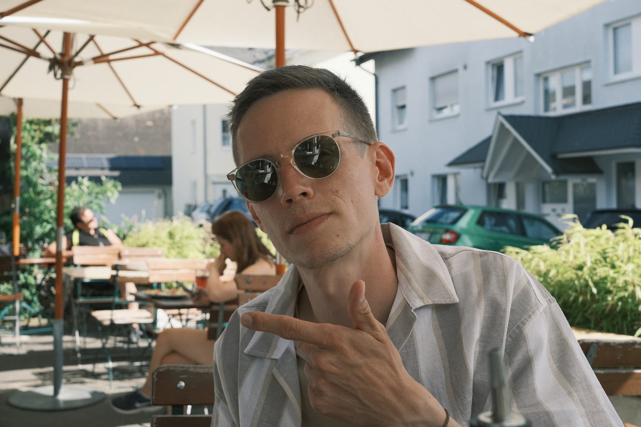 Fabian Schadt at a café, wearing sunglasses and pointing to the side